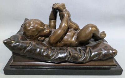 Robert Ockelmann (Germany, 1849-1915), a bronze object: baby on a cushion, Germany, c. 1900